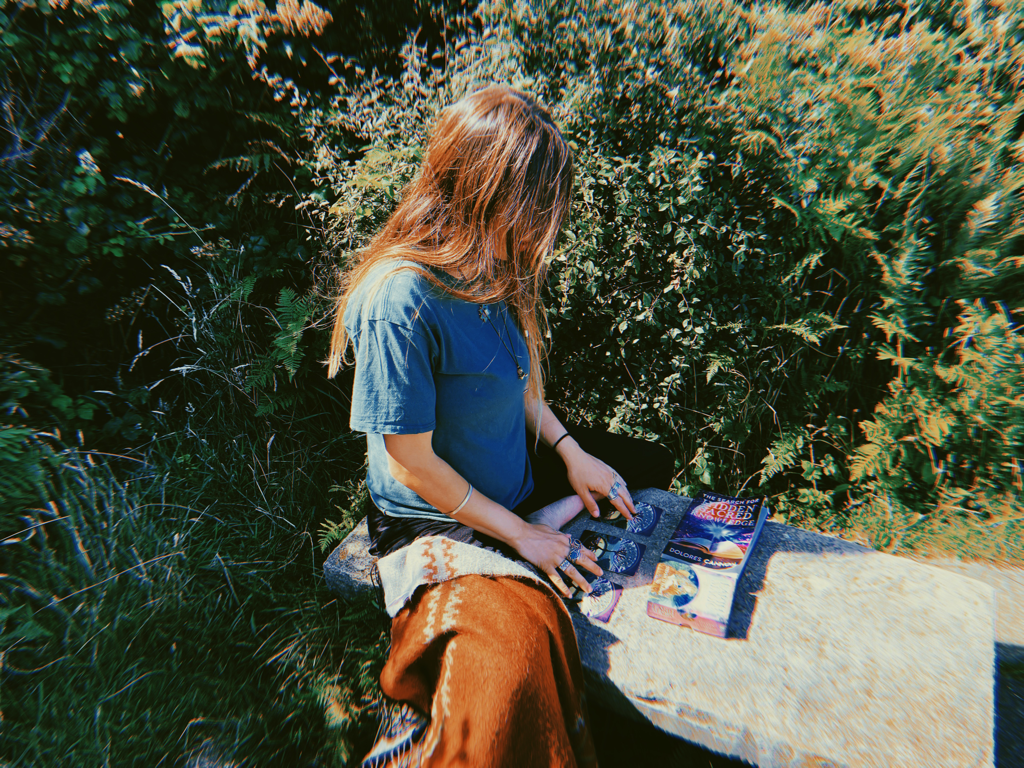 A girl outdoors pulling oracle tarot cards and doing a reading 